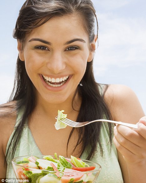 Woman smiling eating a salad