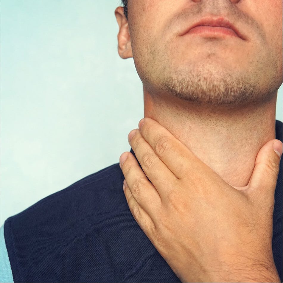 Man touching his neck with his left hand