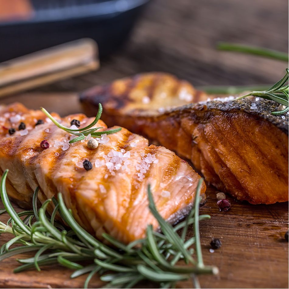 Cooked Salmon sitting on a cutting board