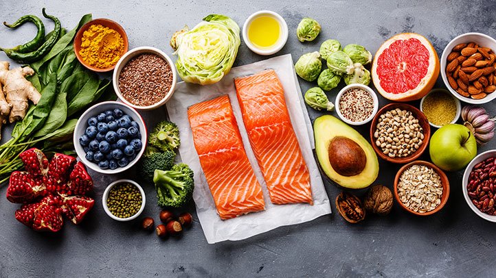 A flatlay of foods: salmon, berries, grapefruit, avocado, and more.