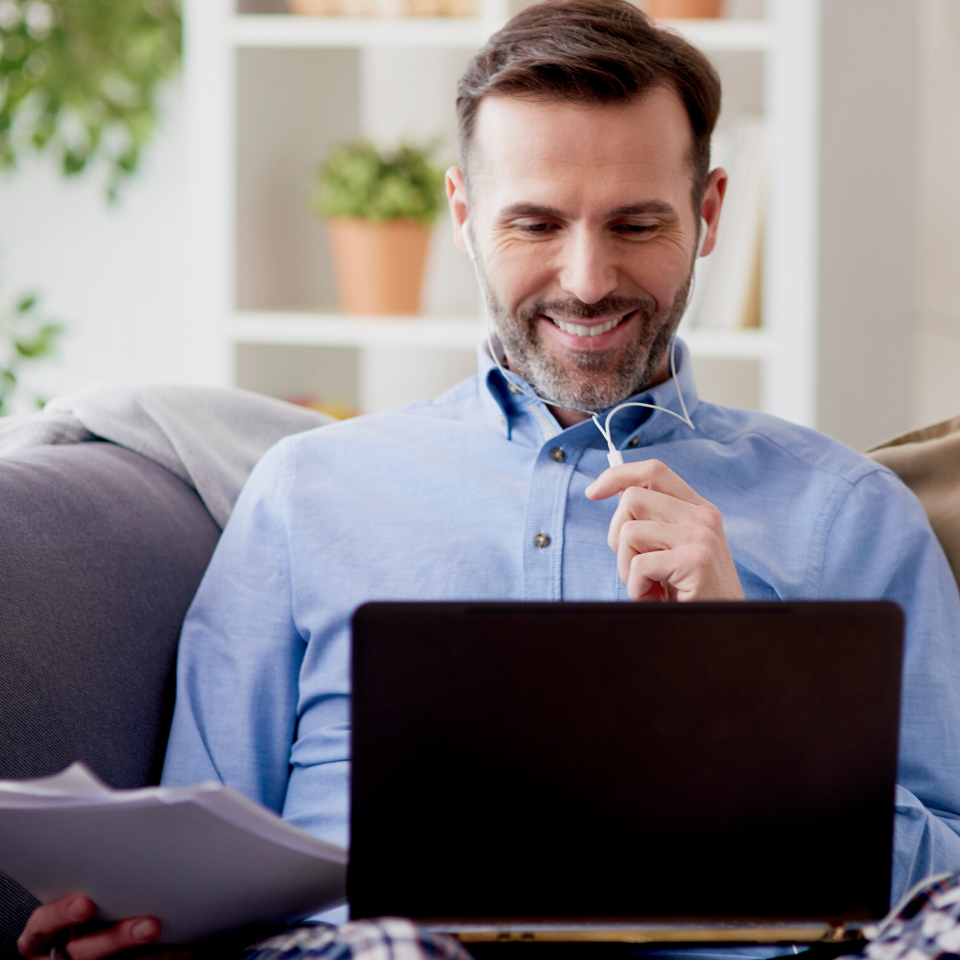 male sitting on couch working on computer