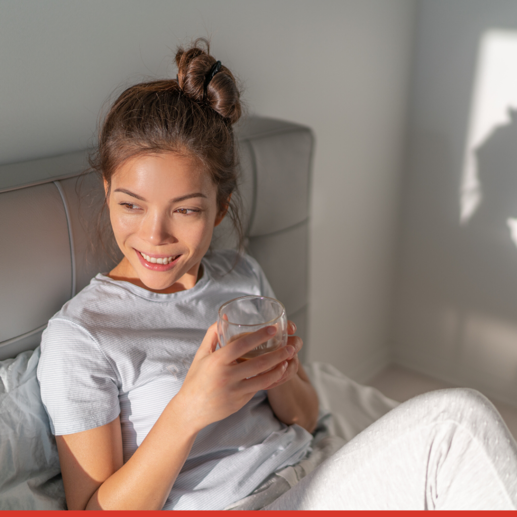 woman sitting in bed with cup of coffee