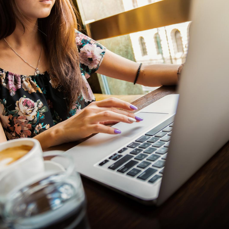 female working on laptop with cup of coffee