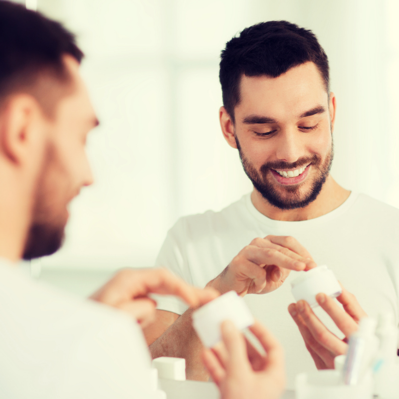 man looking down at skincare container