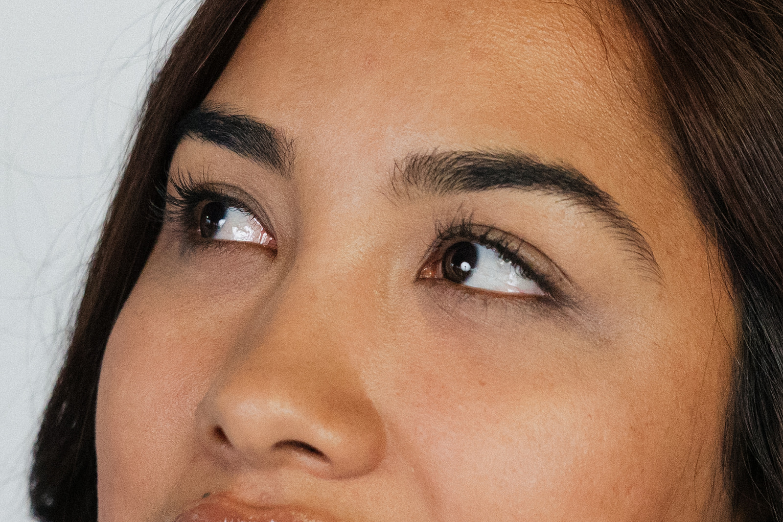 Woman with dark brown eyes staring up and off to the right