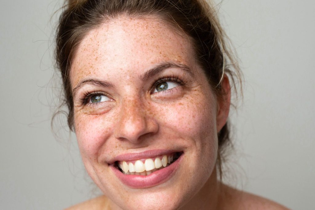 Woman with freckles and green eyes smiling