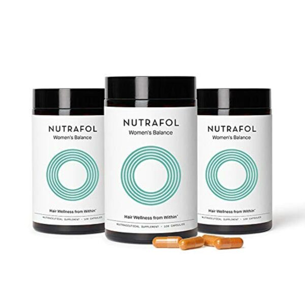 nutrafol tablet bottle with tablets laying in front of bottles