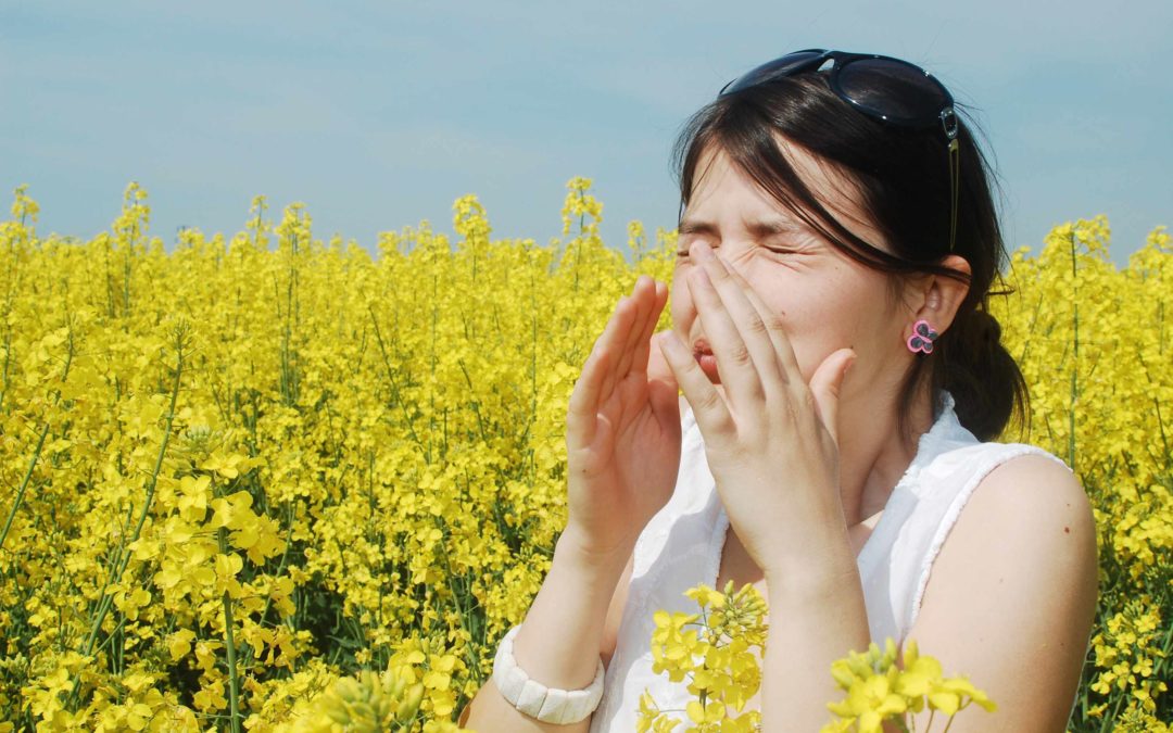 A woman sneezing in a field of wildflowers
